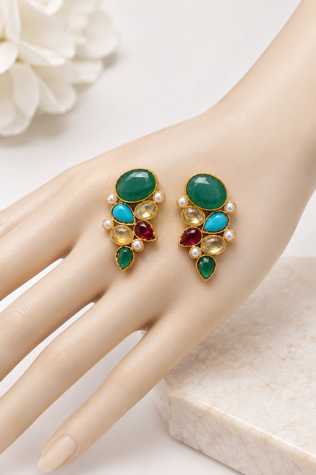 Multicolour cluster earrings displayed on a hand